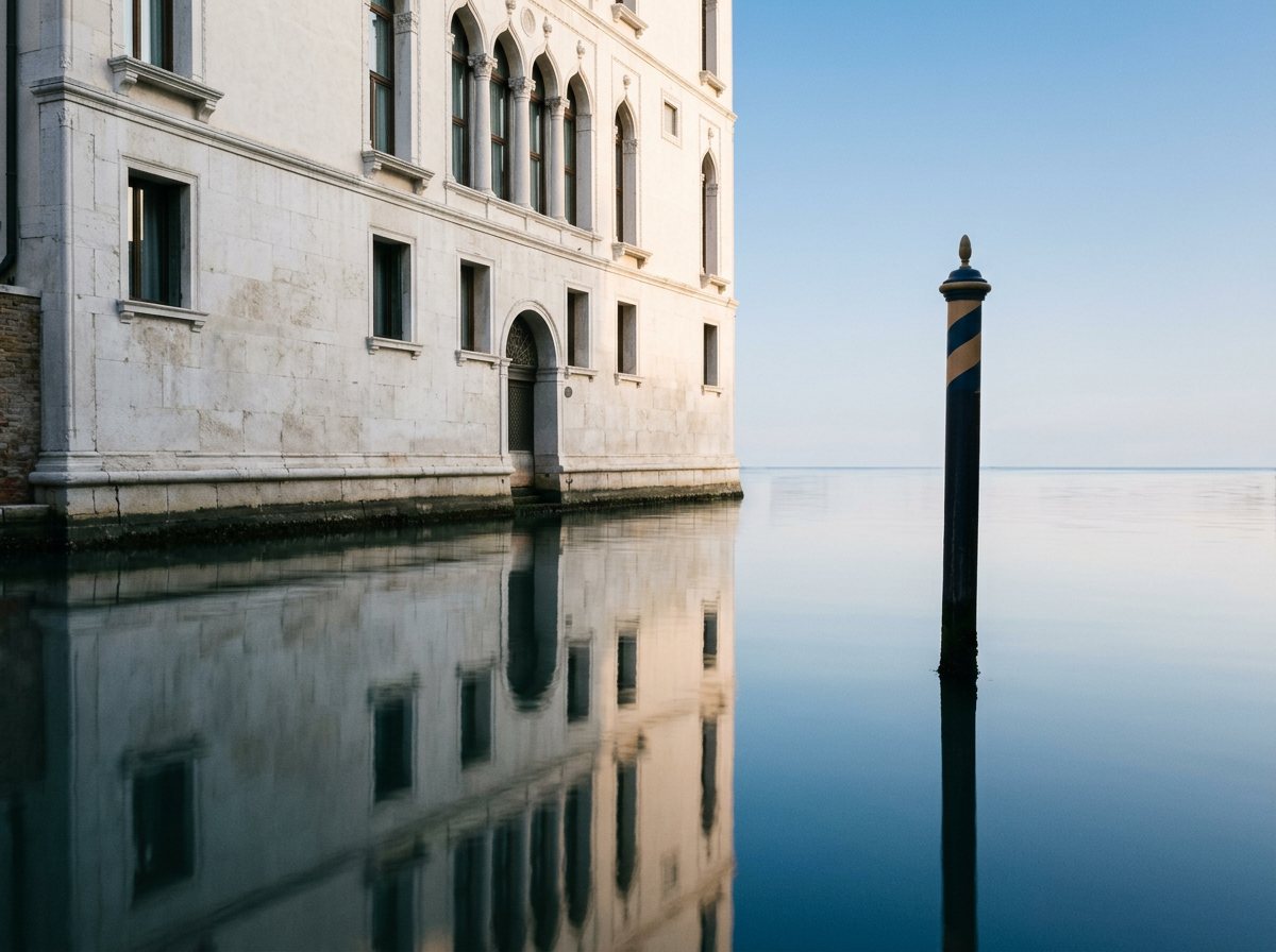 Stiller venezianischer Kanal am frühen Morgen mit spiegelnder Fassade.